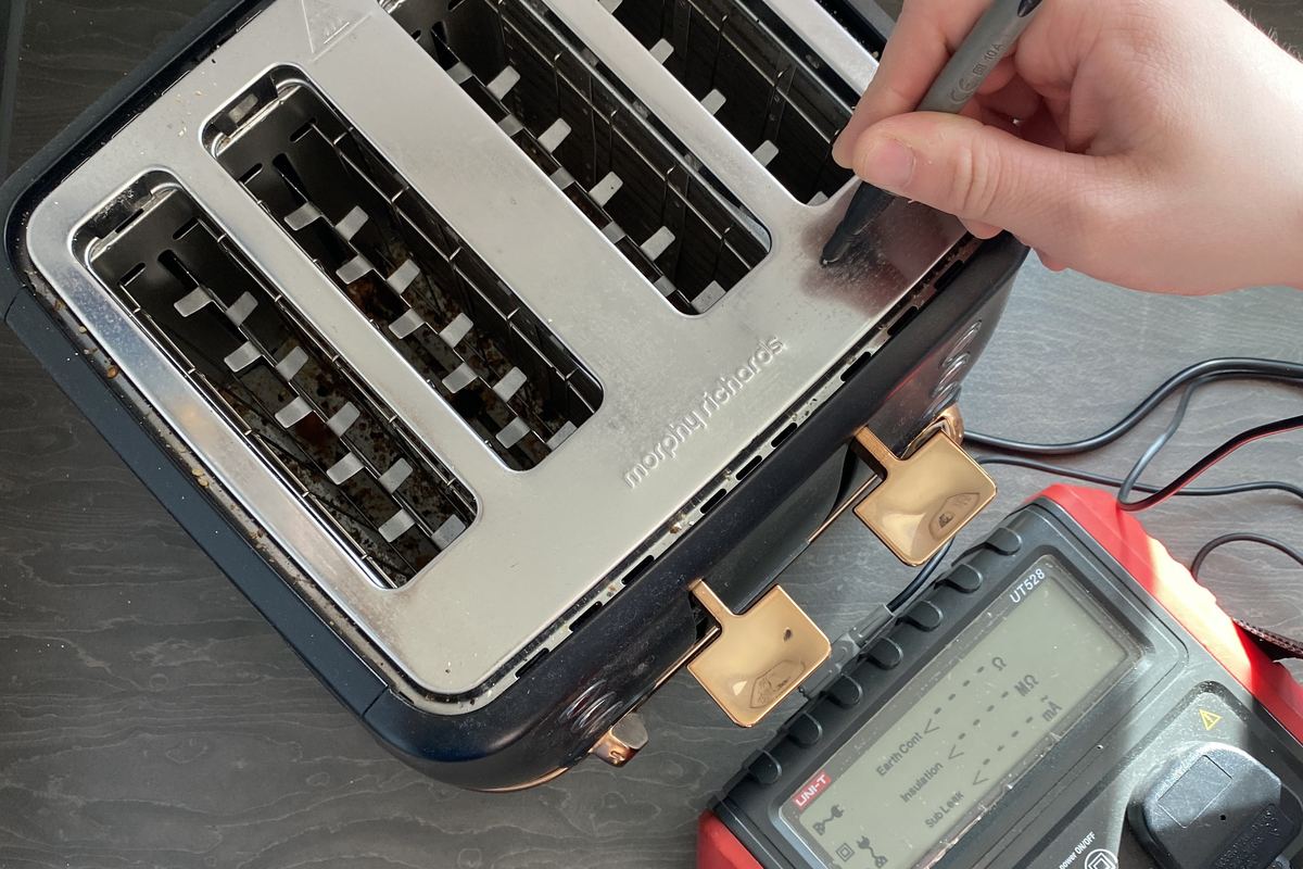 Earth continuity test being carried out on a toaster casing with a test probe